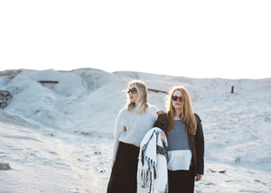 Two girls standing in snow with shades and NOZ reef safe sunscreen on